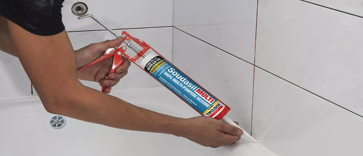 Caulking sealant application on bathroom tile